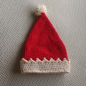 May include: A red crocheted Santa hat with a white pom-pom on top and a white crocheted brim.