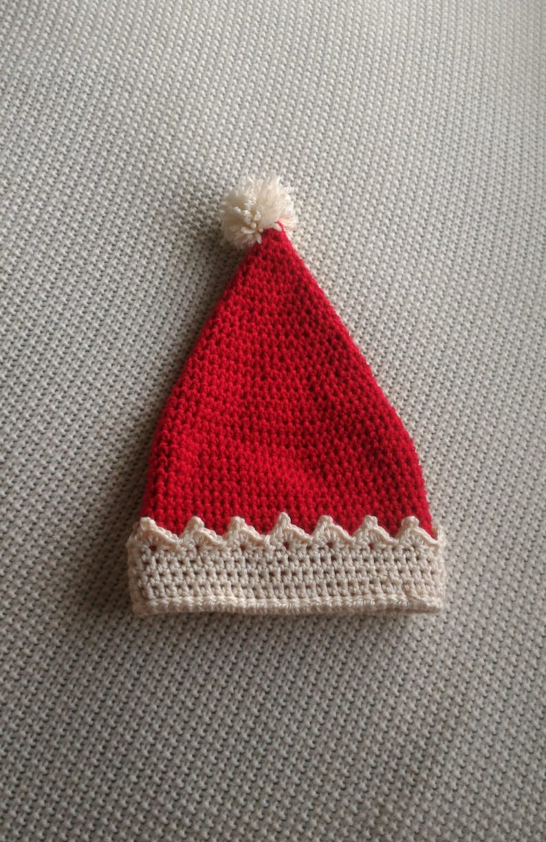 May include: A red crocheted Santa hat with a white pom-pom on top and a white crocheted brim.
