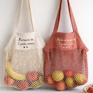 Pode incluir: Uma caneca de cerâmica branca com uma alça preta e o texto "But First, Coffee" em negrito preto. A caneca está sobre uma superfície de madeira. A caneca tem aproximadamente 10 cm de altura.