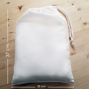 May include: A white drawstring bag made of fabric, measuring 28 inches by 37 inches.