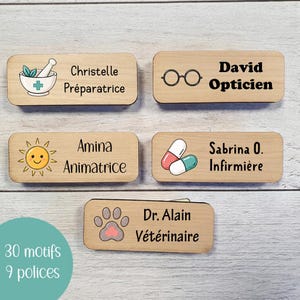 Peut inclure: Cinq badges nominatifs rectangulaires en bois aux coins arrondis, chacun arborant une icône unique et du texte imprimé. Les badges affichent des noms et titres professionnels dont Christelle Préparatrice, David Opticien, Amina Animatrice, Sabrina O. Infirmière et Dr. Alain Vétérinaire.