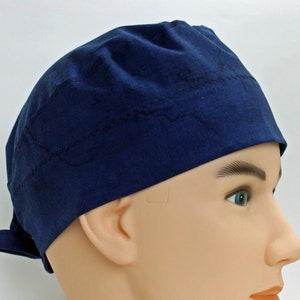 May include: A dark blue scrub cap with a tie on the back. The cap is made of a soft, comfortable fabric.