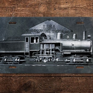 May include: A black and white image of a vintage steam locomotive with the text "LIMA LOCOMOTIVE WORKS, INC." printed on a metal sign.