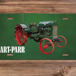 May include: A green and red Hart-Parr 30 tractor on a green license plate background. The tractor has large wheels with red rims and spokes. The license plate has the text "HART-PARR" in white letters.