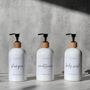 Set of 3 reusable plastic bottles to declutter and organize your shower! 16. oz. white plastic bottle set includes shampoo, conditioner and body wash in a modern script style. Part of the Classic Series by Heartland Lettering.
