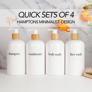 May include: Four white pump bottles with bamboo-style tops. Each bottle is labelled with black text: shampoo, conditioner, body wash, and face wash. The text "Quick Sets of 4" and "Hamptons Minimalist Design" are also visible.