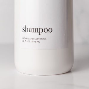 Up close view of minimalist design shampoo bottle label on an empty bathroom dispenser bottle. Set of 4 modern bottles add easy organization to your home decor with a class, minimalist black and white design.