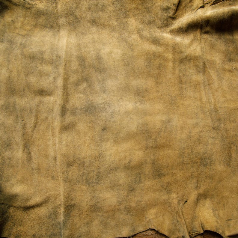 Puede incluir: Primer plano de un trozo de cuero marr&oacute;n con textura arrugada. El cuero tiene un aspecto descolorido y desgastado, con algunas manchas m&aacute;s oscuras.