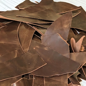 May include: A white ceramic mug with a black handle and the text "But First, Coffee" in a black, bold font. The mug is on a white surface.