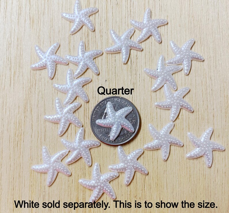 May include: White pearl starfish embellishments, approximately the size of a US quarter.  The starfish are shown on a wooden surface.