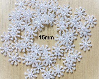 May include: White pearl snowflake embellishments, 15mm in size.  These decorative snowflakes are perfect for adding a touch of sparkle to crafts, cards, and other projects.