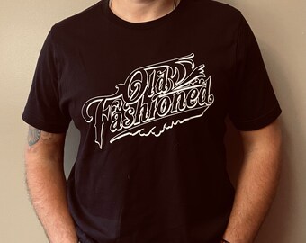 May include: Black t-shirt with a white graphic that says "Old Fashioned" in a stylized font.