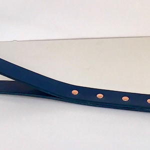May include: A dark blue leather strap with copper rivets and a black cord loop at the end.