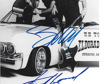 Könnte beinhalten: Schwarz-Weiß-Fotografie einer Band, die mit einem Oldtimer posiert. Die Bandmitglieder tragen Sonnenbrillen und Hüte. Ein Mitglied hält ein Akkordeon, ein anderes eine Gitarre. Das Auto trägt den Text "ZZ Top" und "Eldorado Durango, M" an der Seite.