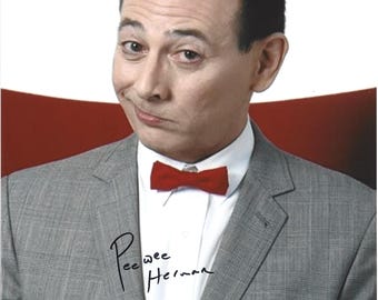 May include: A portrait of Pee-wee Herman wearing a grey plaid suit jacket, a crisp white collared shirt, and a bright red bow tie. A white pocket square is tucked into the jacket pocket. The image features the signature Pee-wee Herman in black ink.