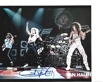 Könnte beinhalten: Ein Foto der Rockband Van Halen, die auf der Bühne auftritt. Die Bandmitglieder spielen Gitarre und Schlagzeug. Die Bühne ist mit Scheinwerfern beleuchtet und hat eine große Löwengrafik im Hintergrund. Der Name der Band ist unten aufgedruckt.
