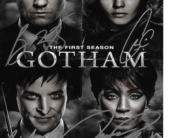 May include: A black and white promotional poster for the television series "Gotham" featuring four cast members. The title "Gotham" is prominently displayed, along with the text "The First Season". The poster includes signatures.