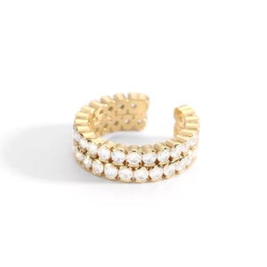 Puede incluir: Pendiente de oreja de oro con dos filas de piedras de circonita cúbica transparentes.