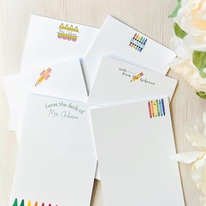 May include: A set of teacher notepads with a variety of colourful crayon and pencil designs. The notepads feature the text "from the desk of Mrs. Gaharan" and "note from Mrs. Gaharan".