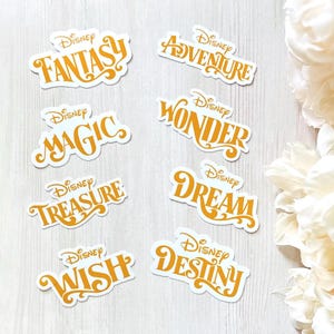 Pu&ograve; includere: Una collezione di adesivi Disney con parole come "Fantasy", "Adventure" e "Magic" in un font arancione. Ogni adesivo ha un bordo bianco ed &egrave; disposto su una superficie con venature di legno chiaro.