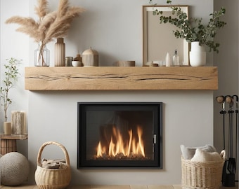 May include: A modern fireplace with a black frame and a roaring fire. The fireplace is set into a white wall with a wooden mantel above it. There are dried pampas grasses in vases on the mantel, along with other decorative items.