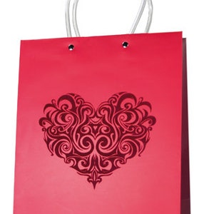 Puede incluir: Bolsa de regalo de papel roja con asa plateada y un diseño de corazón decorativo. El corazón es negro y tiene un patrón de espiral.