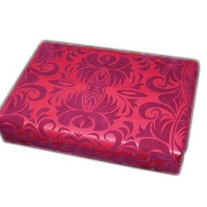 May include: A rectangular gift box wrapped in shiny red paper with a repeating, ornate floral pattern in a darker shade of red. The box is centered on a white background.