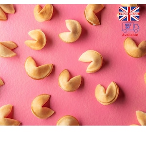 May include: A selection of golden-brown fortune cookies arranged on a bright pink surface. The cookies are open, showing their inner form. The image has a cheerful and vibrant appearance.
