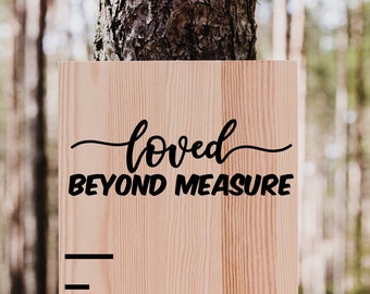 May include: A wooden growth chart with a black ruler and the text "loved beyond measure" at the top. The number "6" is visible on the ruler.