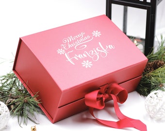 May include: A red gift box with a white ribbon and the text "Merry Christmas Franziska" on the top.