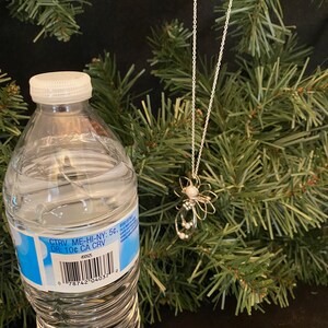1.5-inch Handcrafted Silver Wire Angel Necklace - accented with silver and white beads. Elegant Heavenly Charm - Unique Gift for Her with a bottle.