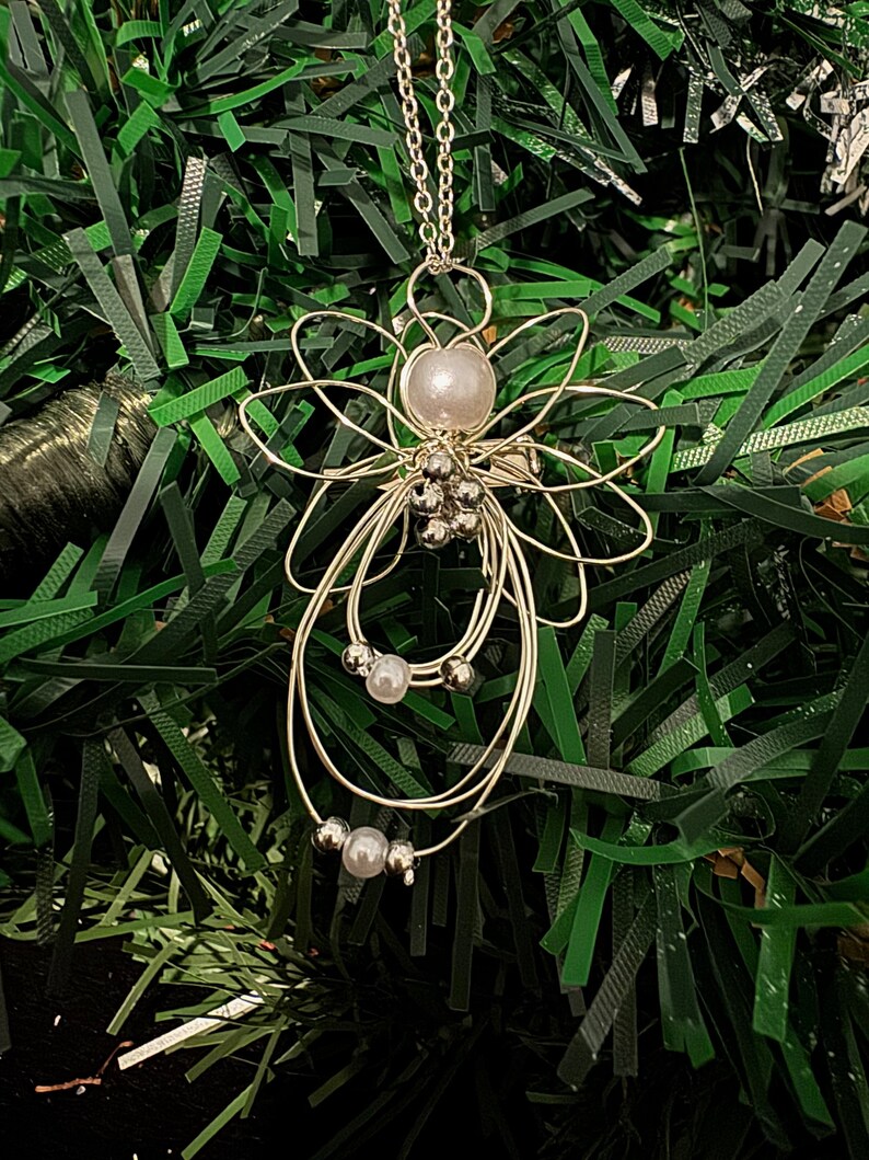 Very close view of 1.5-inch Handcrafted Silver Wire Angel Necklace - accented with silver and white beads. Elegant Heavenly Charm - Unique Gift for Her