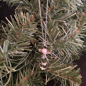 1.5-inch Handcrafted Silver Wire Angel Necklace - accented with silver and white beads. Elegant Heavenly Charm - Unique Gift for Her on a tree.