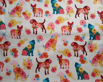 May include: Fabric with a repeating pattern of dogs and floral arrangements in shades of red, pink, yellow, and blue on a cream background. The dogs are stylized with floral patterns.