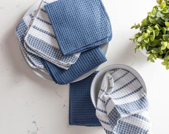 May include: A stack of blue and white striped kitchen towels on a white plate. The towels are folded and have a waffle texture. There is a single towel in a bowl.