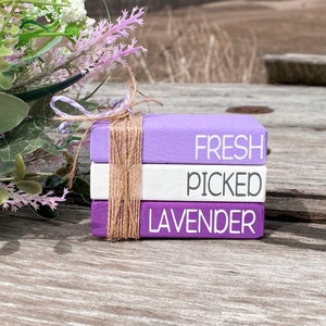 May include: Three stacked wooden blocks painted in shades of purple and white. The top block reads "FRESH", the middle block reads "PICKED", and the bottom block reads "LAVENDER".