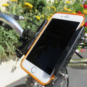 May include: A black and orange smartphone is mounted on a bicycle handlebar. The phone is in a protective case with an orange border. The mount is black and has adjustable knobs. The bicycle handlebars are silver.