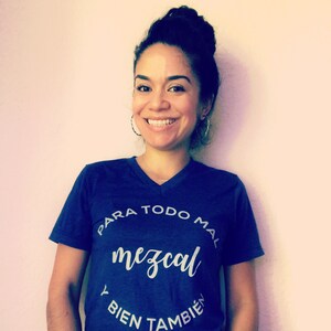 May include: A blue t-shirt with a white circle graphic that says "Para todo mal mezcal y bien tambien".