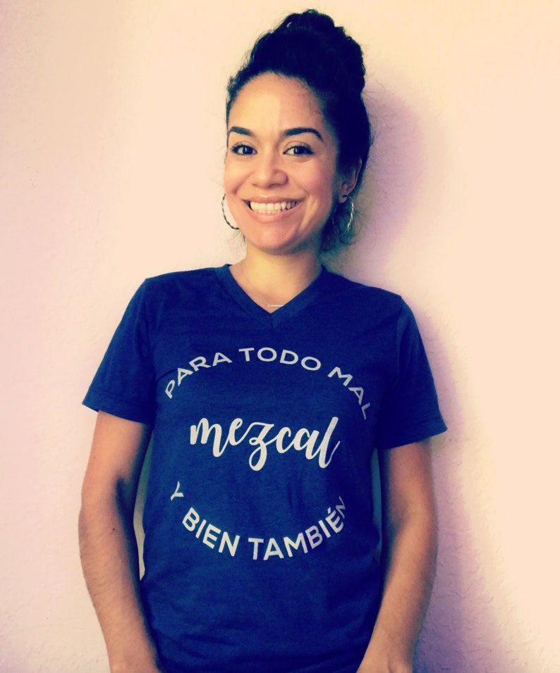 May include: A blue t-shirt with a white circle graphic that says "Para todo mal mezcal y bien tambien".