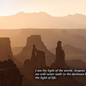 May include: A scenic landscape photograph of a desert canyon with a quote from the Bible, John 8:12, "I am the light of the world. Anyone who follows me will never walk in the darkness but will have the light of life."