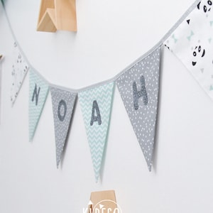 Anpassningsbar vimpelbanderoll med texten "En, två, tre, PANDA!" i mintgrönt, vitt och grått