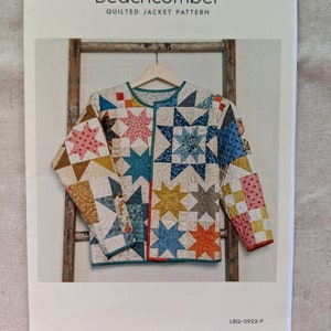 Puede incluir: Un patrón para una chaqueta acolchada llamada "Beachcomber" de Laundry Basket Quilts. El diseño de la chaqueta presenta bloques de edredón en forma de estrella en varios colores, incluyendo azul, rosa y amarillo. El patrón se muestra sobre un fondo blanco.
