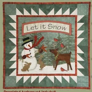 May include: A green and white quilt block with a red and white border. The center of the block features a snowman, a reindeer, and two rabbits in a snowy winter scene. The text "Let it Snow" is displayed above the scene.