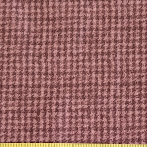 Puede incluir: Primer plano de una tela de pata de gallo rosa y marrón. La tela tiene una textura suave y peluda.
