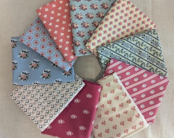 Peut inclure: Dix carrés de tissu avec différents motifs floraux dans des tons de rose, bleu et crème. Les carrés de tissu sont disposés en cercle sur une surface beige.