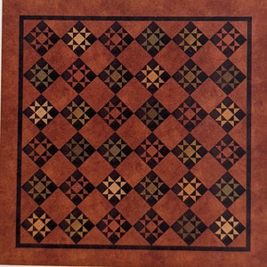 May include: A brown quilt with a repeating pattern of black, green, and orange stars. The quilt is made up of 36 squares.