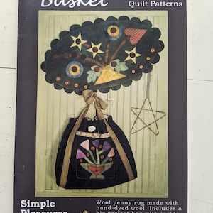 Pode incluir: Caderno de padrão de quilt Wool Basket com um tapete de lã penny tingido à mão e uma bolsa de ombro com bolsos internos e externos. O padrão faz parte da série Simple Pleasures, número 105.  www.QuiltersHome.com