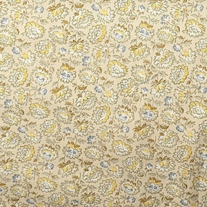 May include: A beige fabric with a repeating pattern of small, stylized yellow and blue flowers. The fabric has a subtle texture.