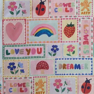 以下が含まれることがあります： 虹、花、テントウムシ、キノコ、ハート、そして「フラワーチャイルド」、「愛してる」、「ドリーマー」、「アーティ」という言葉が描かれたカラフルなパッチワークデザインです。