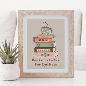 May include: A framed print with a stack of books and a cup of coffee on top. The text reads "Bookmarks Are For Quitters."